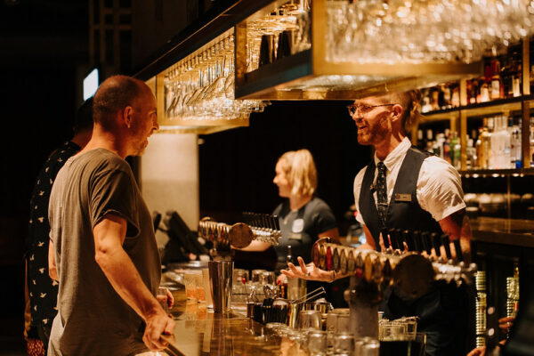 Bar manager serving customer.